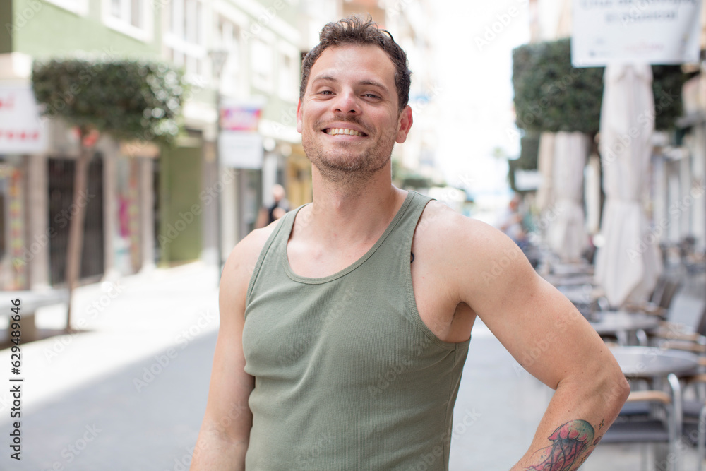handsome man smiling happily with a hand on hip and confident, positive, proud and friendly attitude handsome man smiling happily with a hand on hip and confident, positive, proud and friendly attitude