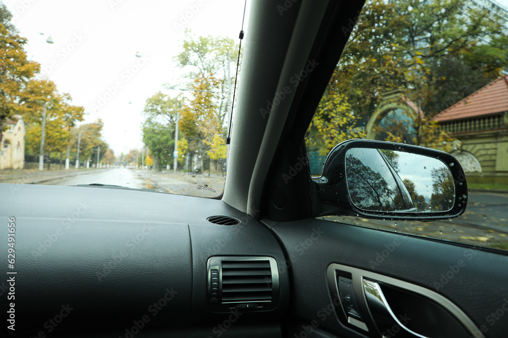 Fototapeta premium Rearview mirror of a car in rainy weather