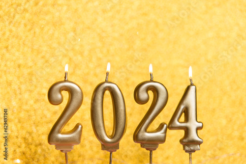 Happy new year 2024 golden background with number. Christmas card banner with golden decorative candles. Mockup, postcard.