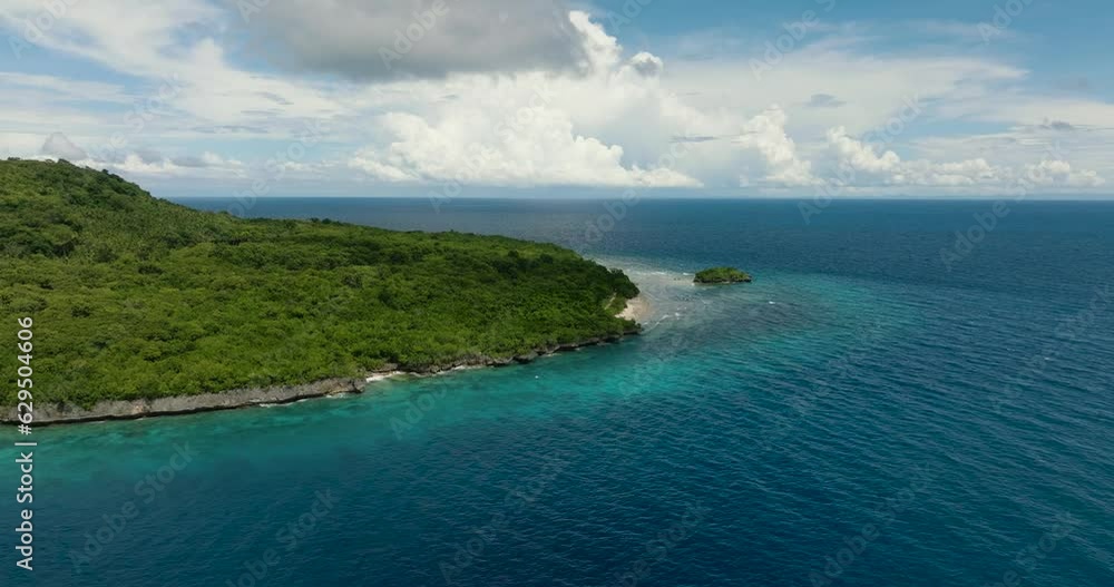 Flying above the Beautiful Tropical Island with a tiny Island near the white beach coast that is completely surrounded by water. Siquijor, Philippines. Flying above the Beautiful Tropical Island with a tiny Island near the white beach coast that is completely surrounded by water. Siquijor, Philippines.