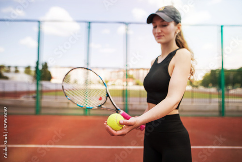 Sports girl with racket and tennis ball. A beautiful young girl is exercising. © Tania