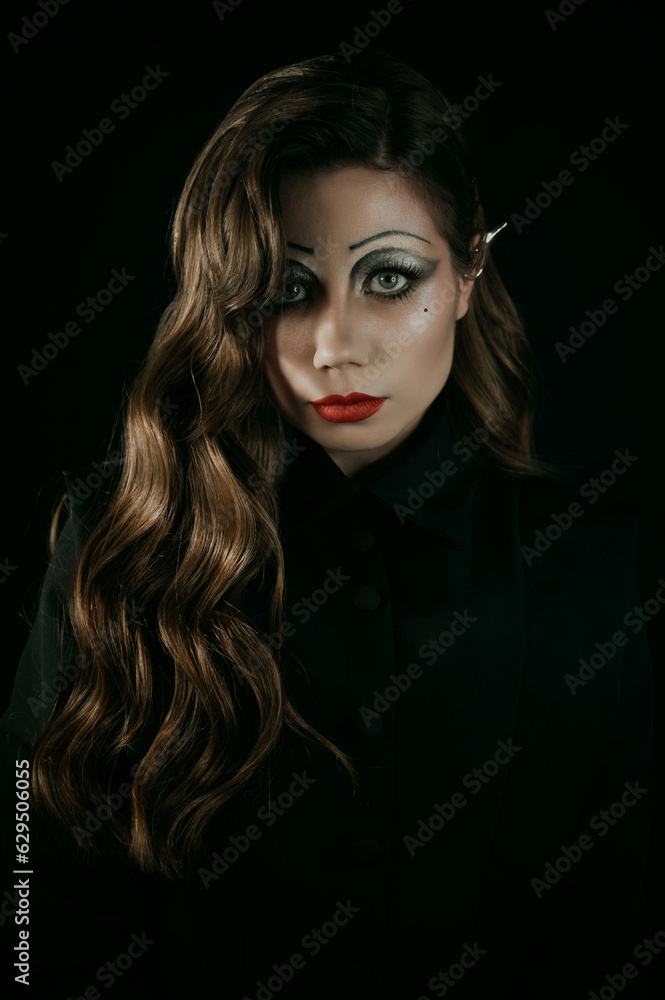 Portrait of a young woman in a Gothic gloomy image of a witch or vampire. Halloween costume. Vertical photo. Portrait of a young woman in a Gothic gloomy image of a witch or vampire. Halloween costume. Vertical photo.