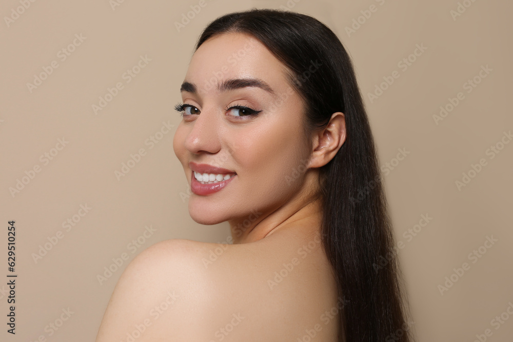 Portrait of beautiful young woman with elegant makeup on dark beige background Portrait of beautiful young woman with elegant makeup on dark beige background