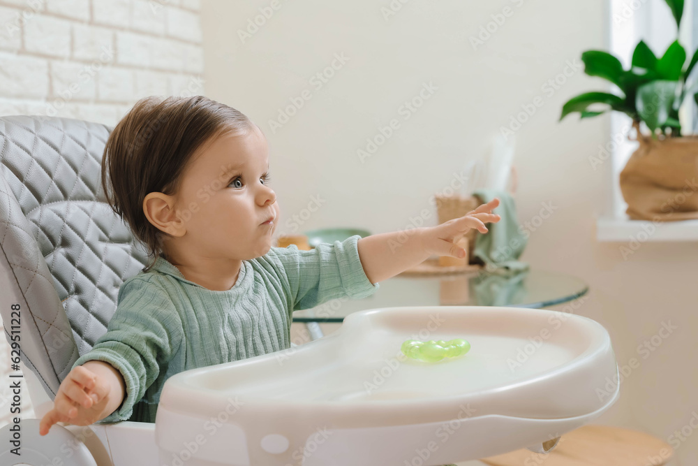 Cute little baby sitting in high chair indoors Cute little baby sitting in high chair indoors