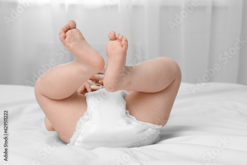 Little baby in diaper lying on bed indoors  closeup