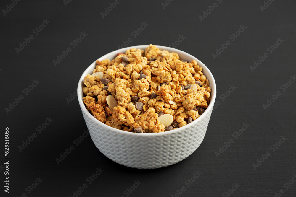 Protein Granola with hazelnut, almond, and chocolate in a Bowl, side view. Protein Granola with hazelnut, almond, and chocolate in a Bowl, side view.