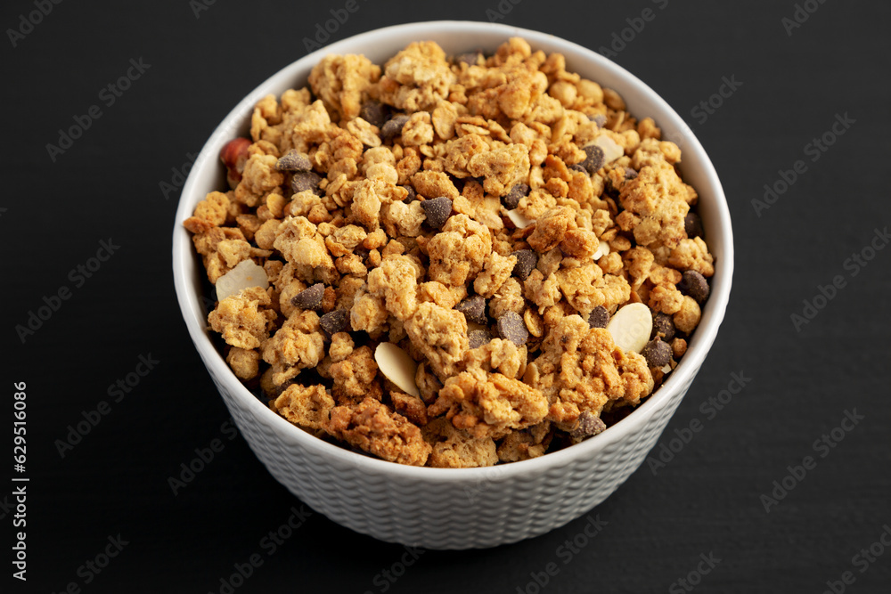 Protein Granola with hazelnut, almond, and chocolate in a Bowl, side view. Protein Granola with hazelnut, almond, and chocolate in a Bowl, side view.