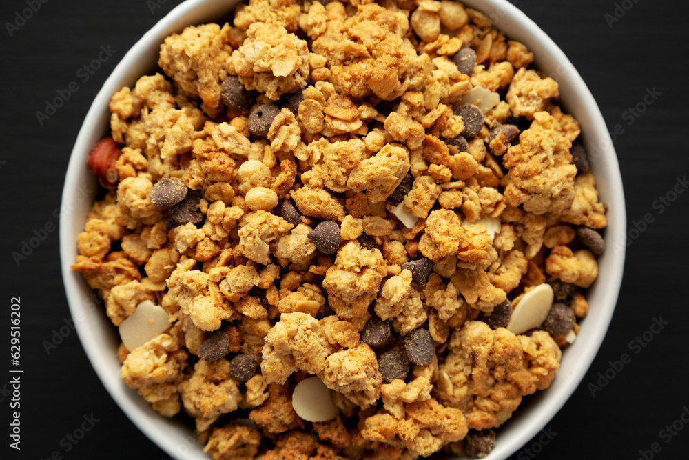 Protein Granola with hazelnut, almond, and chocolate in a Bowl, top view. Protein Granola with hazelnut, almond, and chocolate in a Bowl, top view.