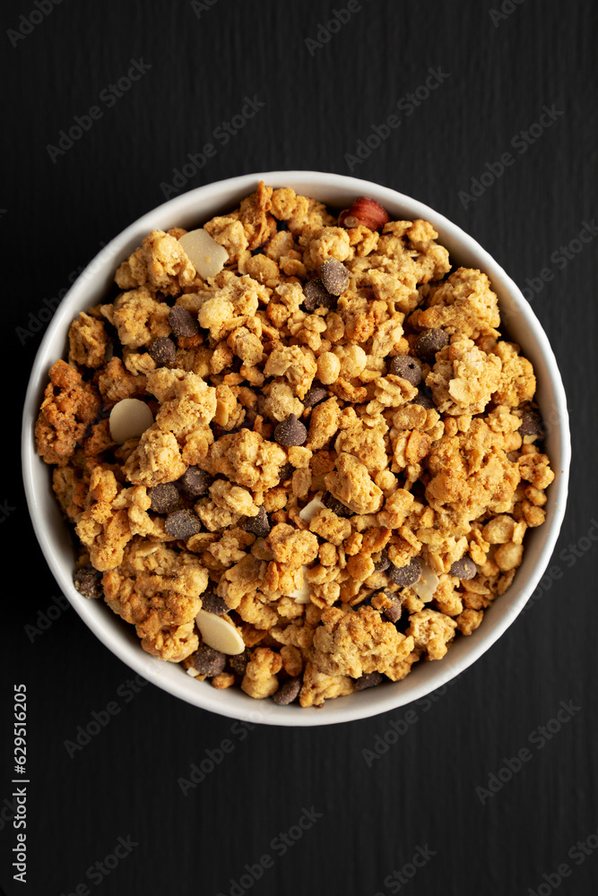 Protein Granola with hazelnut, almond, and chocolate in a Bowl, top view. Protein Granola with hazelnut, almond, and chocolate in a Bowl, top view.