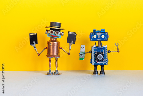 Media information storage electronic equipment concept. Robots with usb and memory cards. Creative design robotic toy on yellow gray background