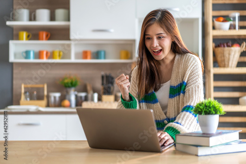 Young smiling asian woman happy relax use laptop conference work,learning education, shopping, study online, webinar, podcast,creative girl feel good, positive, success, excited, surprised at home