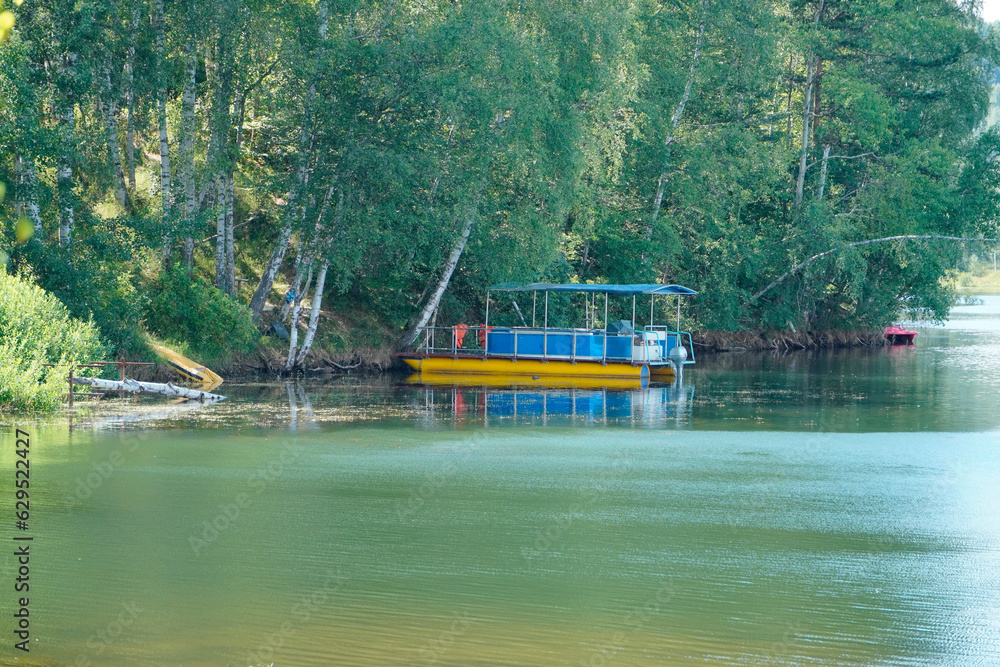 river boat with green river surrounded by grass and trees river boat with green river surrounded by grass and trees
