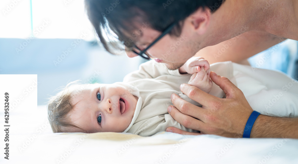 Happy father playing with his little baby boy in the bedroom. Closeup. Happy father playing with his little baby boy in the bedroom. Closeup.