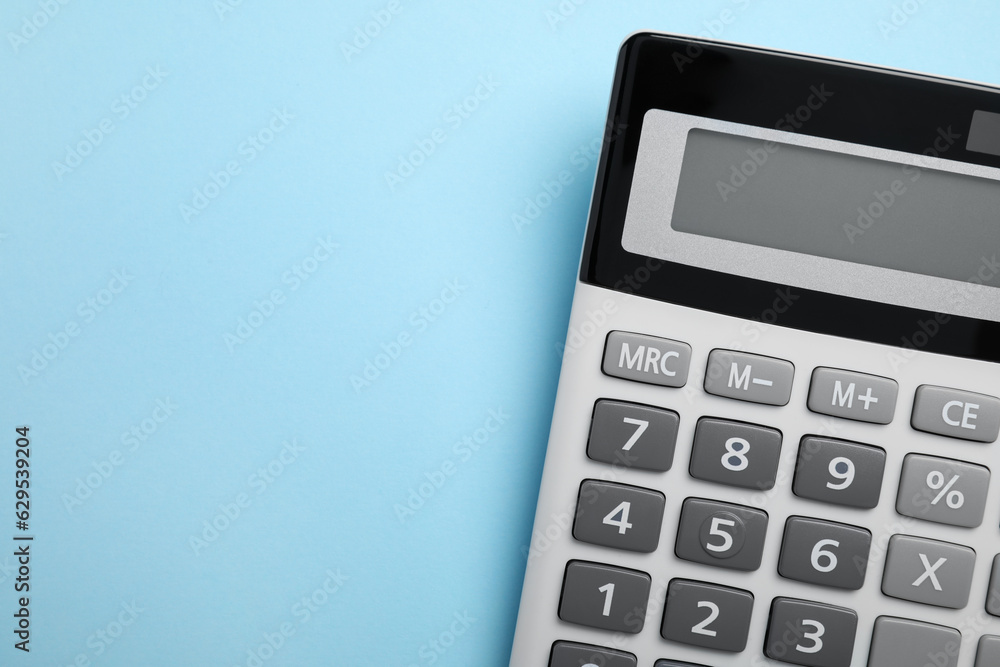 Calculator on light blue background, top view. Space for text Calculator on light blue background, top view. Space for text