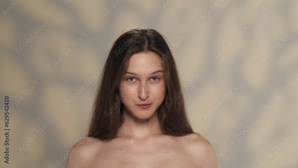 Appealing female model with long shiny hair and makeup looking at the camera Appealing female model with long shiny hair and makeup looking at the camera