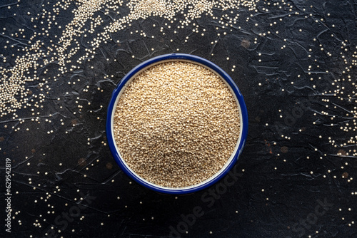 Quinoa in a bowl, healthy organic wood, uncooked, top shot on black