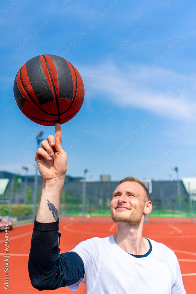 Close-up of a guy basketball player spinning a basketball on his finger showing his basketball freestyle skills 