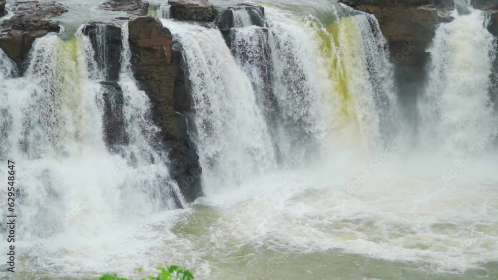 Slow mo shot of Gira waterfall flowing in full force from above the cliff at Waghai on the way to Saputara hill station in Gujarat, India. Waterfall of Sahyadri's during the monsoon season in India. Slow mo shot of Gira waterfall flowing in full force from above the cliff at Waghai on the way to Saputara hill station in Gujarat, India. Waterfall of Sahyadri's during the monsoon season in India.