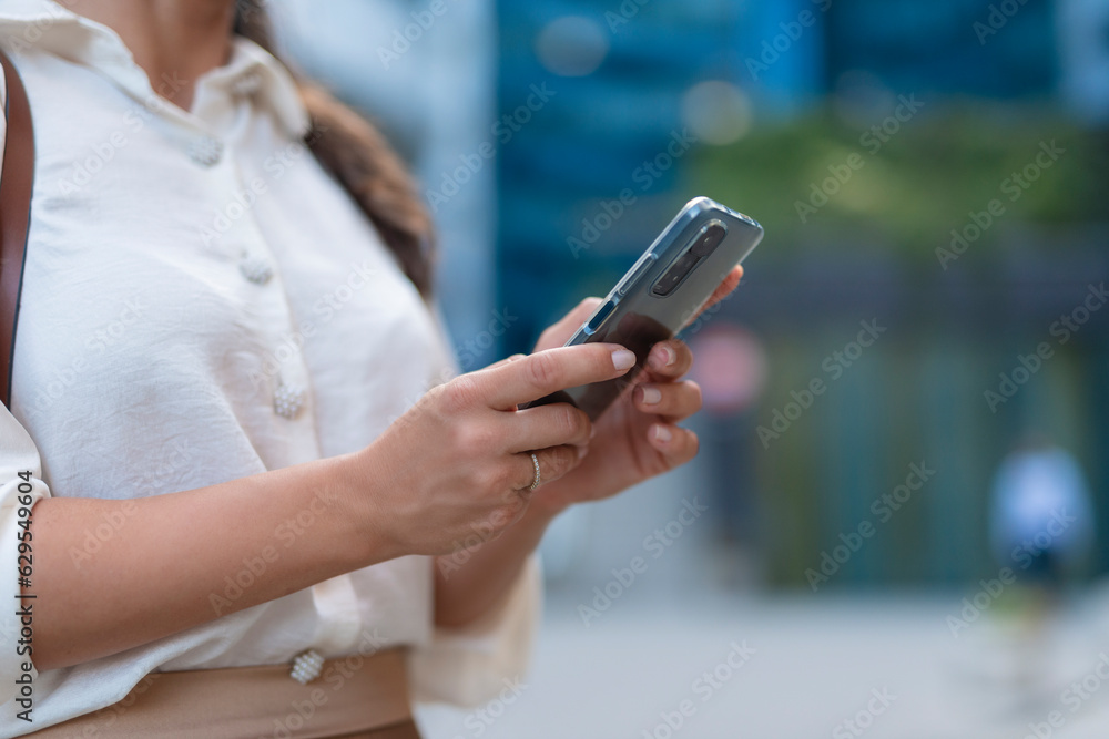 Closeup of young woman holding phone in hands Closeup of young woman holding phone in hands