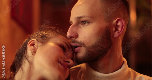 An young carefree romantic happy couple in love is having fun and drinking coffee while enjoying a breakfast together in city center cafeteria on a weekend in a sunny day.