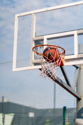 A close-up of a basketball hoop into which a basketball hits the concept of admiration for the game of basketball and love of working out  © Guys Who Shoot