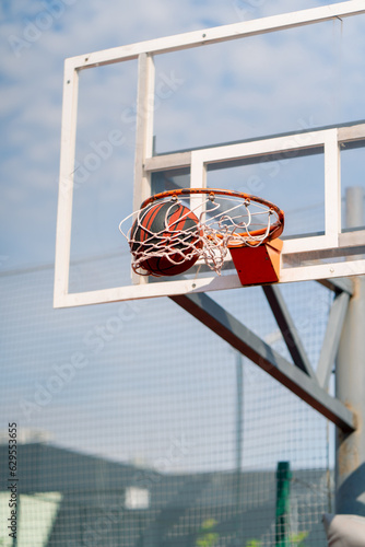 A close-up of a basketball hoop into which a basketball hits the concept of admiration for the game of basketball and love of working out  © Guys Who Shoot