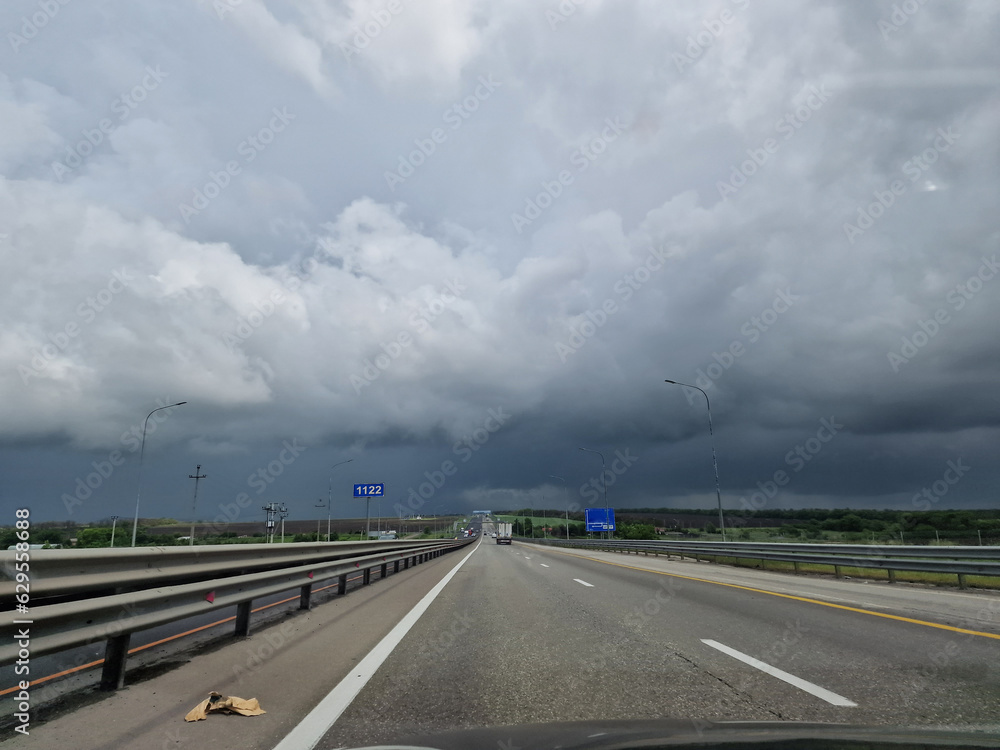 Fototapeta premium Empty highway, minimalistic photo. There are no cars and a view of the gray clouds. Natural disasters