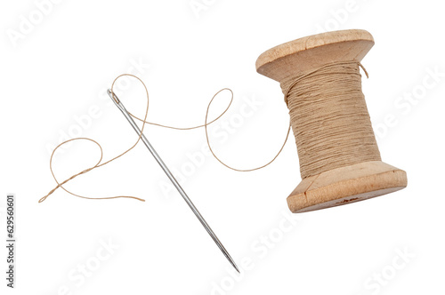 Obraz na płótnie Old wooden spool of thread and needle on a white background