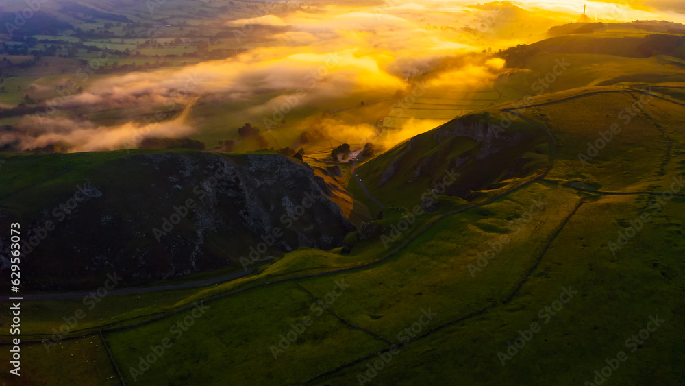 Amazing view in Brecon Beacon national park, Wales, United Kingdom. Dragons Back ridge in the Black Mountains at sunset. Welsh Countryside with Cloud and Mist over Mountains and Hilltop. 