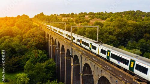 UK Commuter Train Travelling Across a Viaduct at Sunset. 