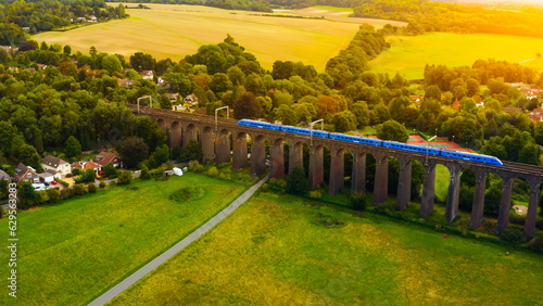 UK Commuter Train Travelling Across a Viaduct at Sunset. 
