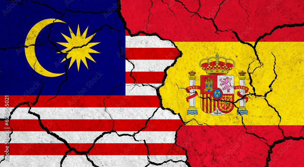 Flags of Malaysia and Spain on cracked surface - politics, relationship concept