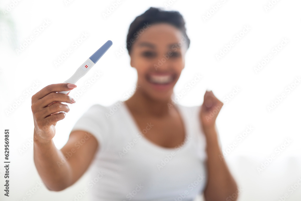 Young Happy African American Female Holding Pregnancy Test At Home