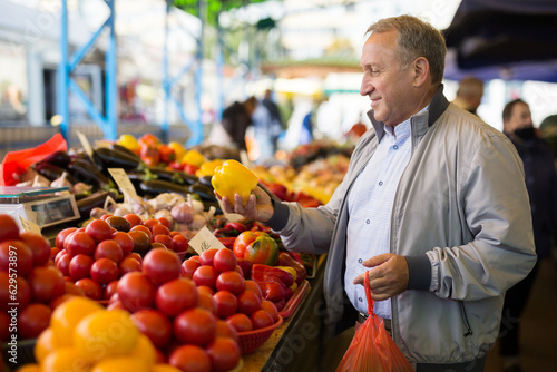 Man purchasing peppers in greengrocery