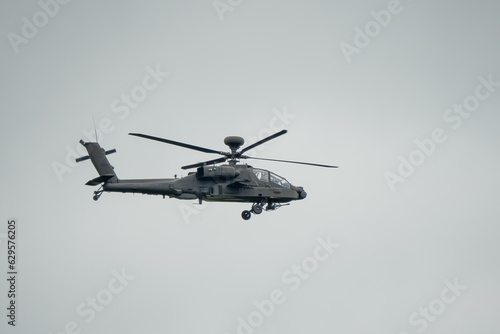 British army AH-64E Boeing Apache Attack helicopter in level flight action, Wiltshire UK