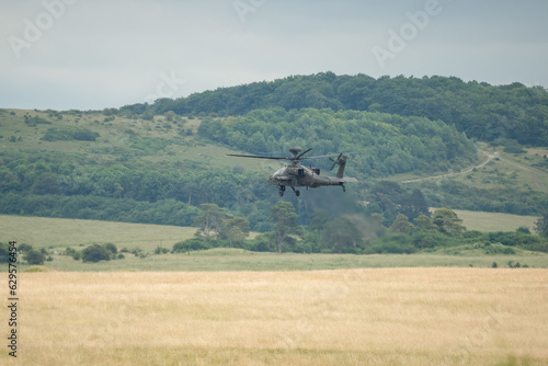 British army AH-64E Boeing Apache Attack helicopter in low level flight action, Wiltshire UK
