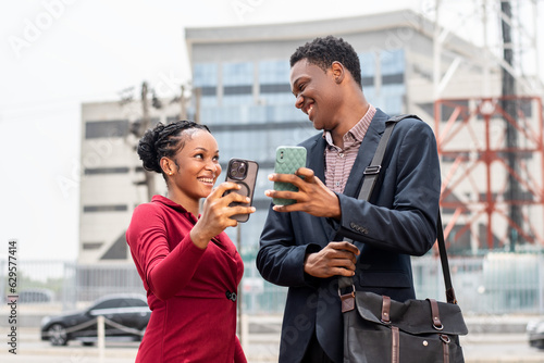 excited young african man and woman check their phones