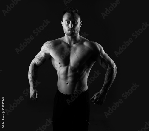 Black and white photo of a strong muscular man. Bodybuilding, torso.