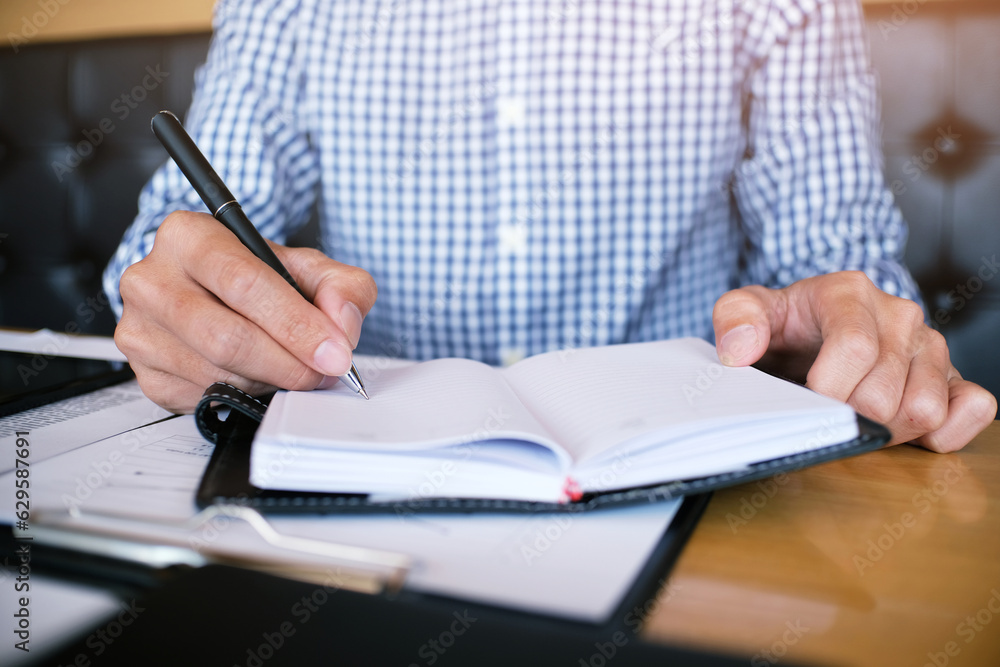 Man student writes information from portable tablet while prepare for lectures in University campus Man student writes information from portable tablet while prepare for lectures in University campus