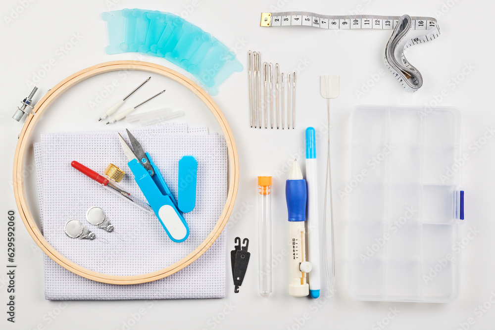 Set of items for needlework, cross stitching and embroidery isolated on white background, hoop, needles, canvas