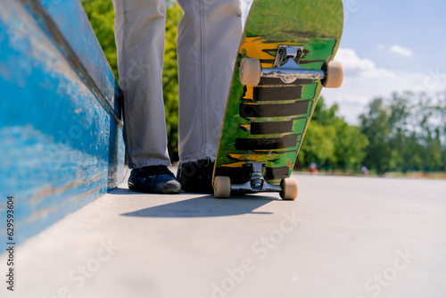 Close-up of a skateboarder's legs with a skateboard while resting between tricks at a city skatepark 