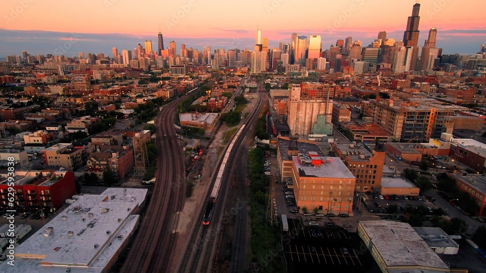Fototapeta premium Chicago Skyline from Drone Over Fulton Market with Metra Train Inbound at Sunset