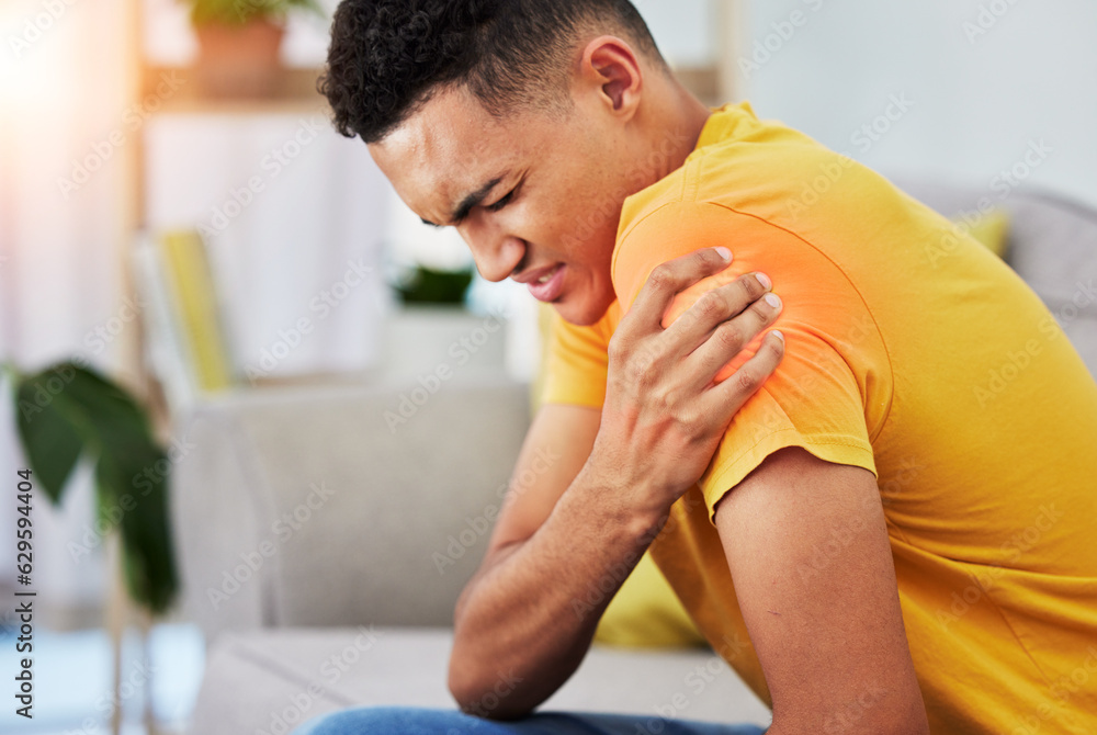 Man, sofa and shoulder pain in home, massage and relief, stress or injury in living room. Health, wellness and self care, person on couch with muscle problem, fatigue or physical therapy in apartment Man, sofa and shoulder pain in home, massage and relief, stress or injury in living room. Health, wellness and self care, person on couch with muscle problem, fatigue or physical therapy in apartment