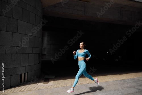 Beautiful fit young woman jogger is running outdoors