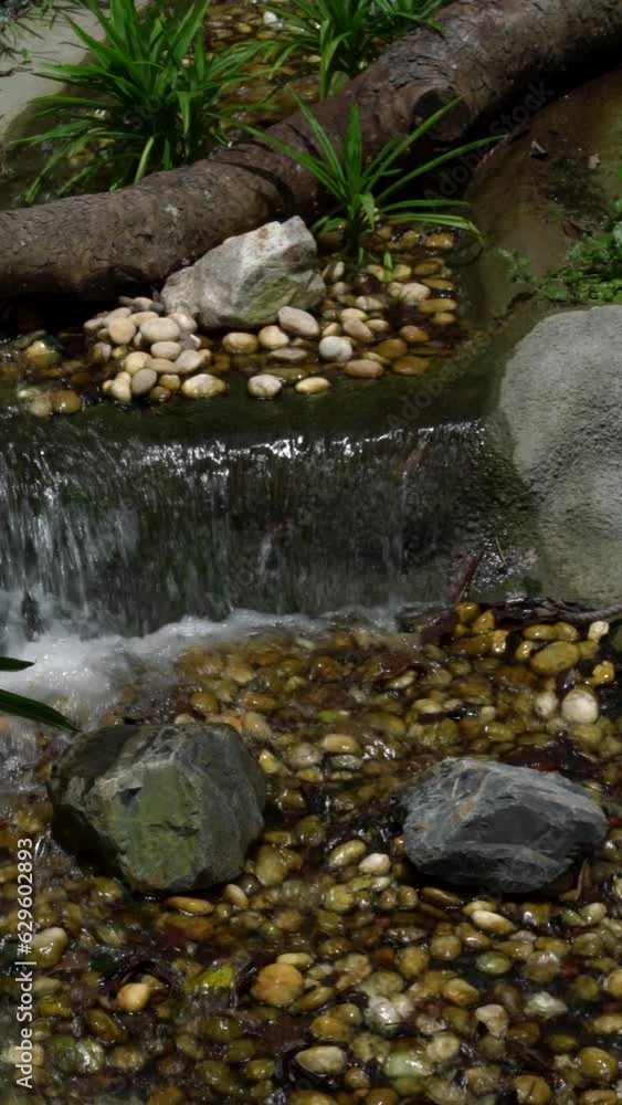 Vertical view of a small water cascade flowing over rocks Vertical view of a small water cascade flowing over rocks