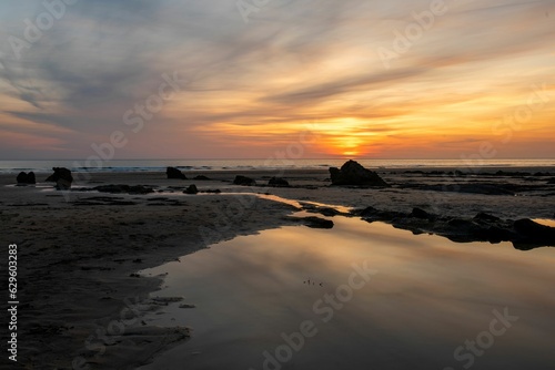 Tranquil sunset view of a beach with rocks and water