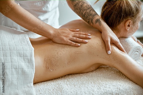confident female specialist is doing relaxing body massage for beautyful slim caucasian lady at minimalistic spa salon