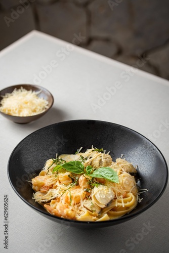 Bowl of freshly-made delicious pasta with seafood on the table