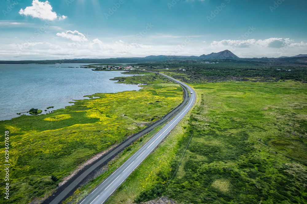 Highway road through mossy remote wilderness by coastline in summer Highway road through mossy remote wilderness by coastline in summer
