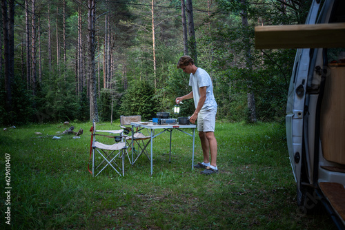 A boy cooking in the forest